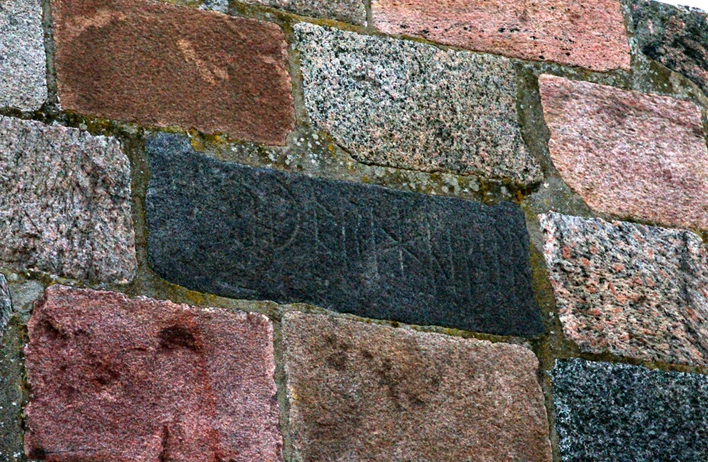 Runesten muret mellem granitkvadrene